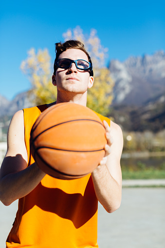 Basketball player focuses with the ball, outdoor court