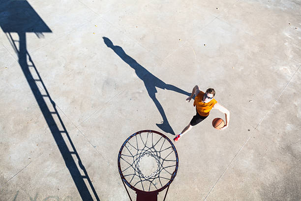 giocatore di basket di corse a canestro hoop - basketball slam dunk basketball hoop sport foto e immagini stock