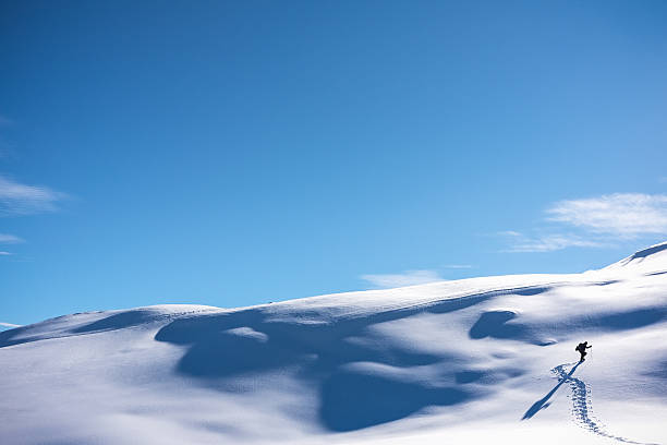 Hiker walking up snowy mountain