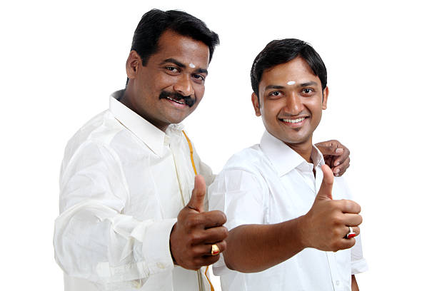 Happy Traditional Indian young people showing thumbs up on white.