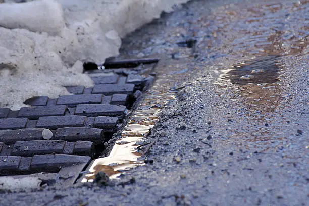 Winter - A wet frozen ground in front of a manhole cover