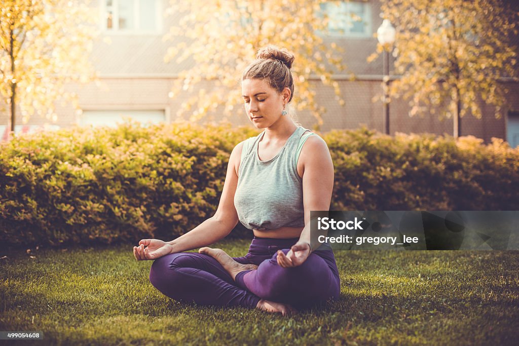 Yoga Yoga meditation in lotus pose in park.  Young woman in peace, soul and mind zen balance concept. Toned picture Women Stock Photo