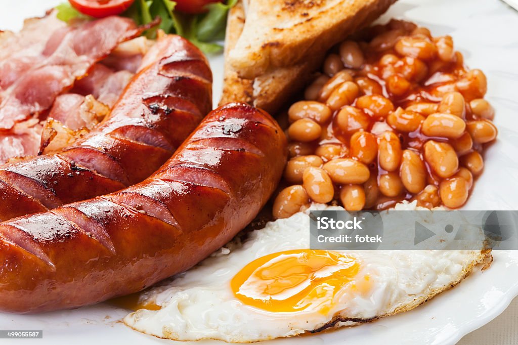 Desayuno inglés completo con tocino, salchichas, huevos y judías en salsa de tomate - Foto de stock de Al horno libre de derechos