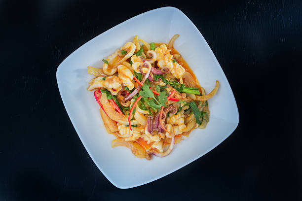 istock Stir Fried squid with salted egg york on black background 499059692