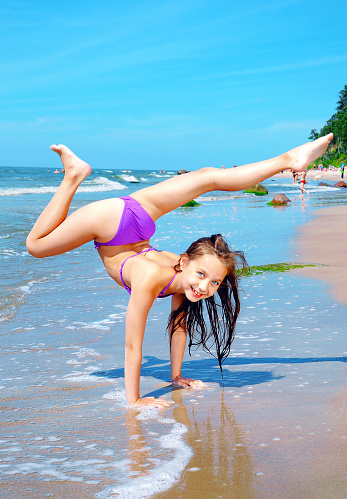 Flexible niña jugando en la playa photo