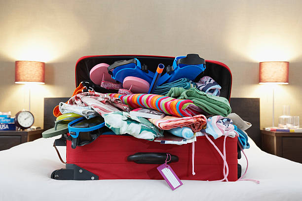 Open suitcase on bed stock photo