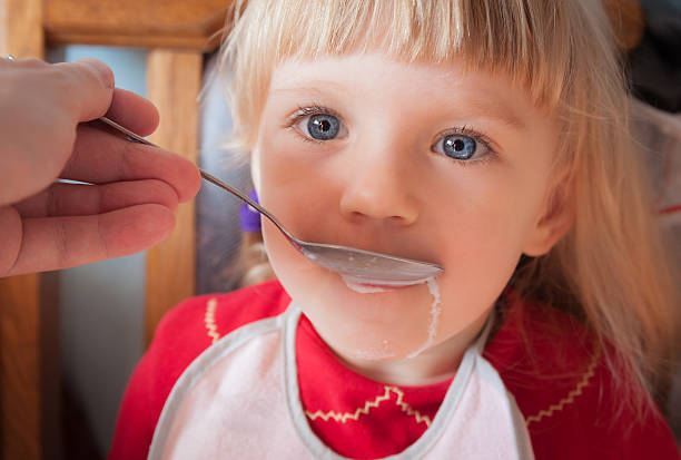 istock Baby girl being fed by hand. 499084995