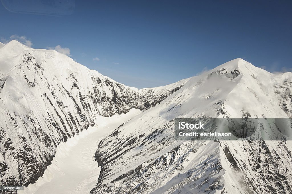 Snow covered mountain tops on a clear day. High peaks in Denali National Park, USA. Glacier formed in the valley between. Alaska - US State Stock Photo