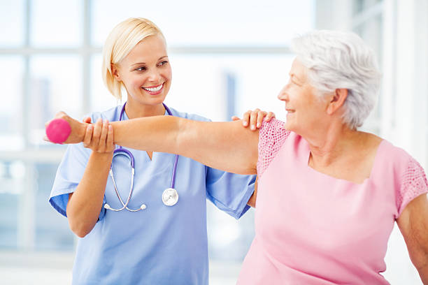 istock Doctor Assisting Senior Patient In Lifting Dumbbell 499086835