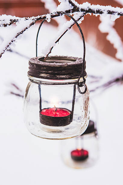 coberta de neve com lanternas de natal com galhos de árvore - tea light votive candle candle candlelight - fotografias e filmes do acervo