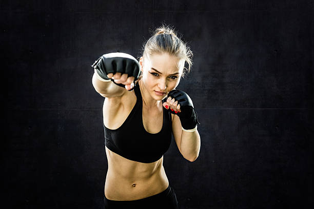 Women Fighter Punching Close Up Women Fighter Punching White Background.  Wearing black sparing gloves. kickboxing photos stock pictures, royalty-free photos & images