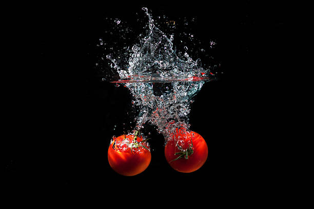 Fresh Red Tomatoes Splash in Water stock photo