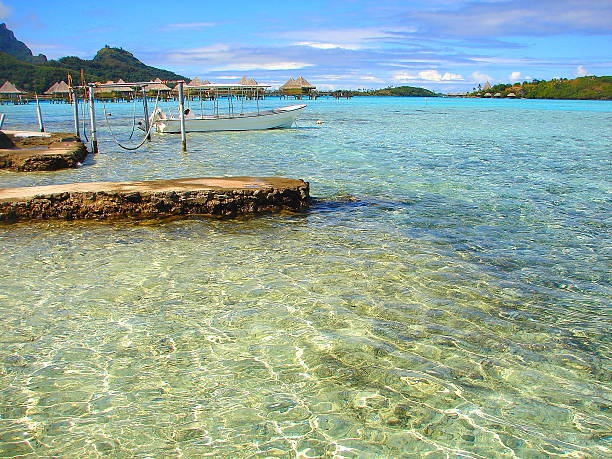 bora bora, bangalôs e barco de pesca na praia, cais turquesa polinésia - french polynesia pier lagoon nautical vessel - fotografias e filmes do acervo