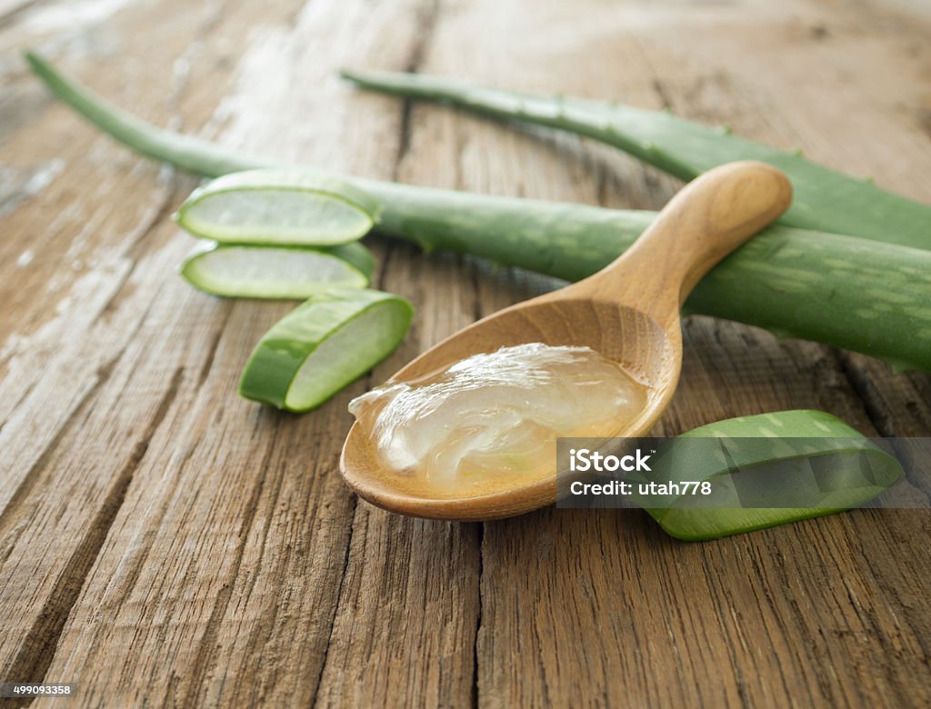 aloe vera gel aloe vera gel on wooden spoon with aloe vera on wooden table Aloe Stock Photo