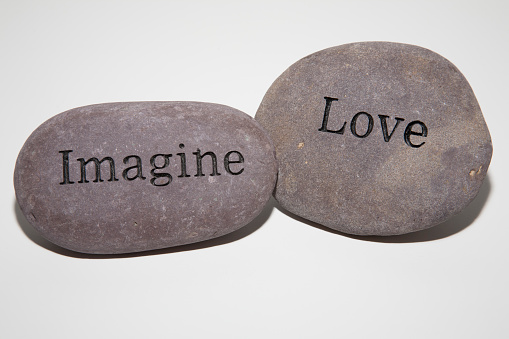 Love and Imagine stone on white background