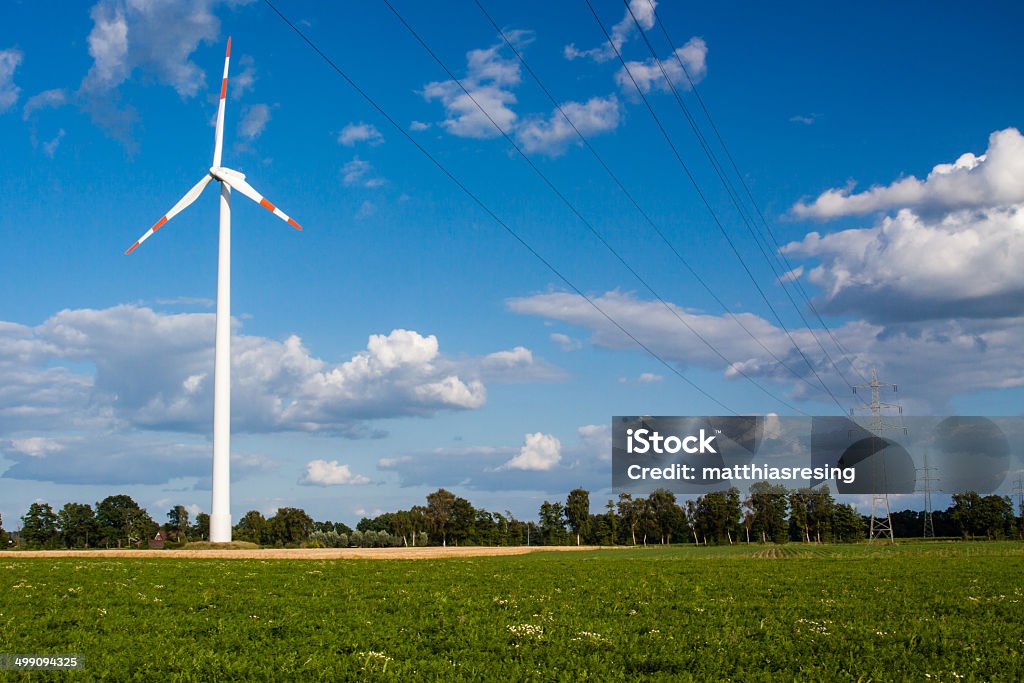 Wind turbine behind high-voltage line The idea was to visualize green electricity Blue Stock Photo