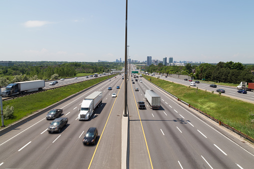 Part of Highway 401 in Toronto during the day showing the blur of traffic on the road