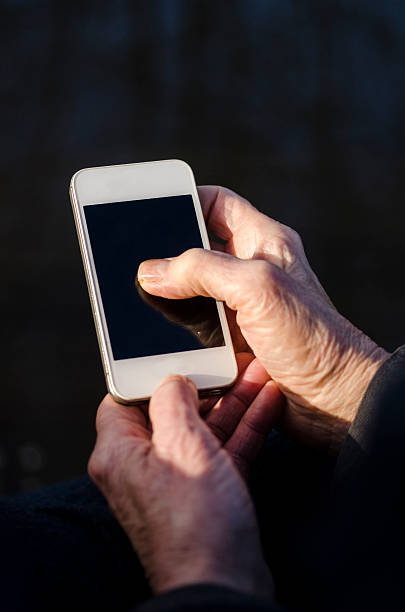 istock Older woman holding and communicate on a smartphone 499096856