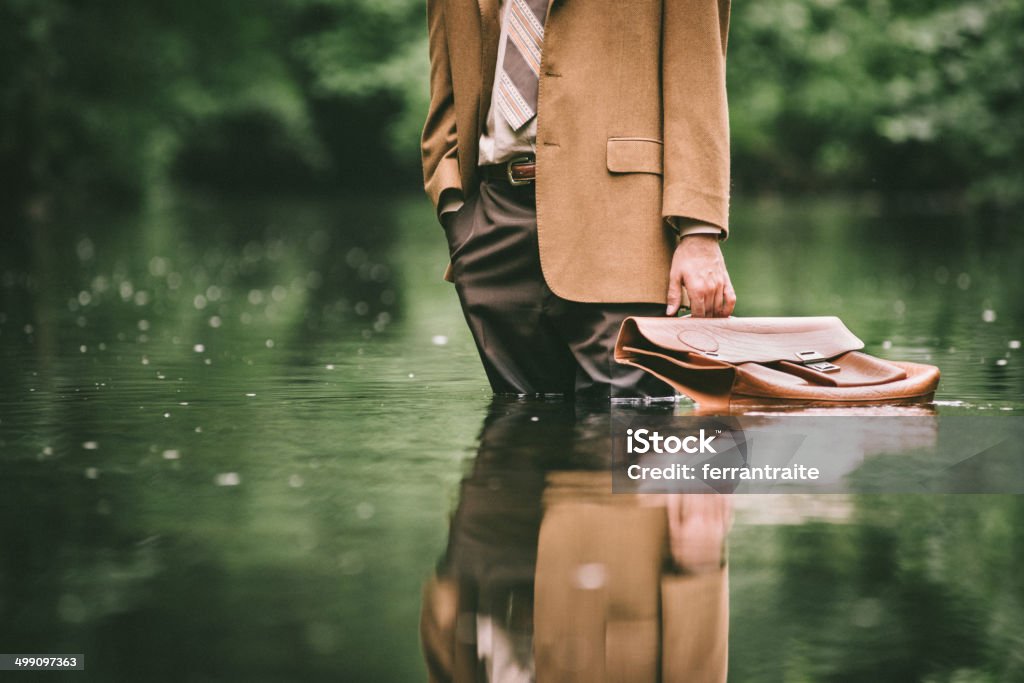 Climate Change as Economic Issue Businessman standing in the water Climate Change Stock Photo