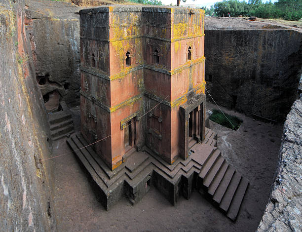 Lalibela, Ethiopia: rock-hewn Church of Saint George Lalibela, Amhara region, Ethiopia: rock-hewn Church of Saint George / Biete Giyorgis - carved from red volcanic rock in the shape of a cross - 12th century - the most famous of the eleven monolithic churches in Lalibela - 45º view - Ethiopian Orthodox Tewahedo Church - UNESCO world heritage site - photo by M.Torres the church of saint george lalibela ethiopia stock pictures, royalty-free photos & images