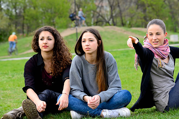 istock Three young women looking and pointing in a park 499113089