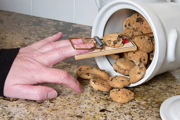 Hand stuck in a mousetrap after being pranked in the cookie jar