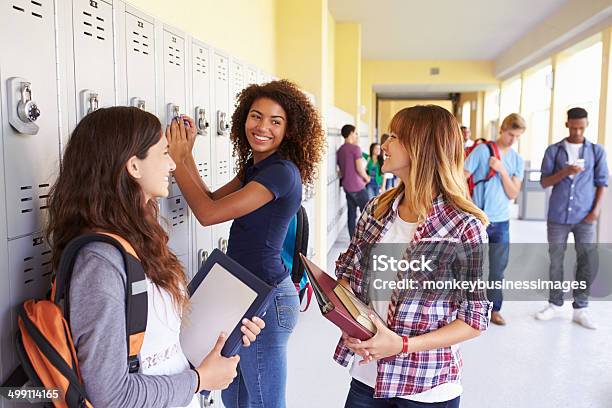 Group Of Female High School Students Talking By Lockers Stock Photo - Download Image Now