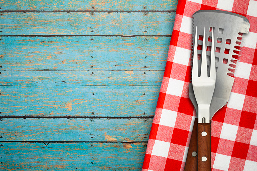 Grilling fork and spatula on red gingham table cloth