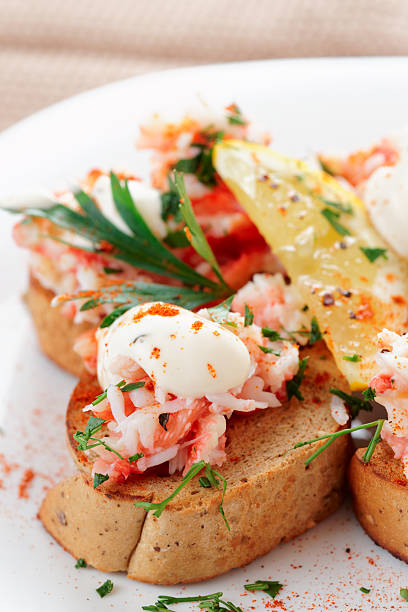 Crab meat with toast, sauce and fresh herbs in plate