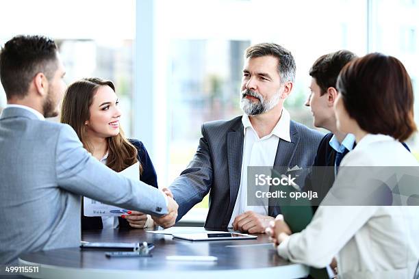 Hombres De Negocios Estrechándose Las Manos Acabado De Una Reunión Foto de stock y más banco de imágenes de Reunión de negocios