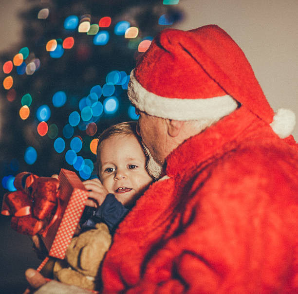 istock Santa Claus Giving Gift To Boy 499119092