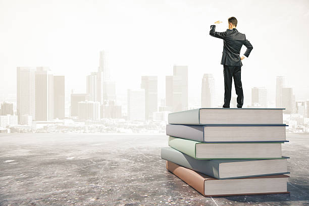 istock Businessman standing on a stack of books and looks away 499122014