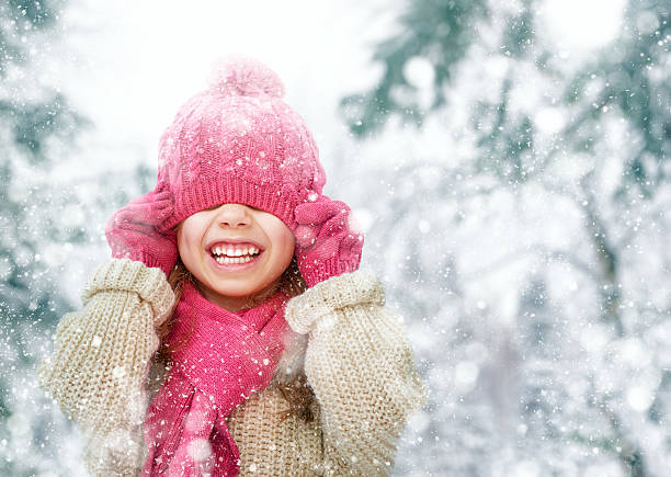 girl playing on a winter walk Happy child girl playing on a winter walk in nature kids winter fashion stock pictures, royalty-free photos & images