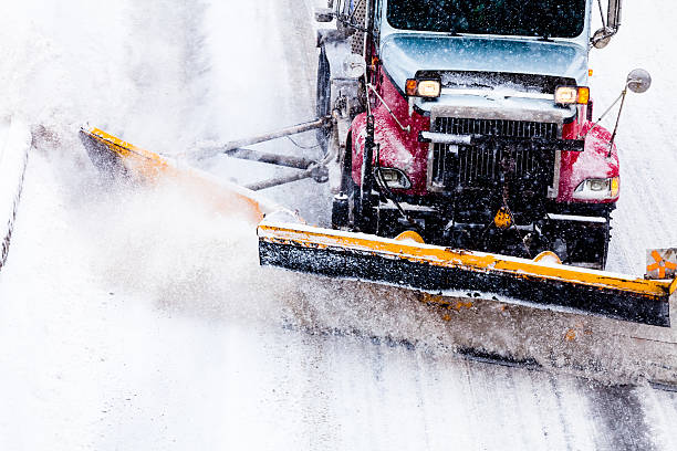 Snowplow removing the Snow from Highway during a Snowstorm stock photo