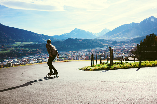 Man riding on longboard in mountains 