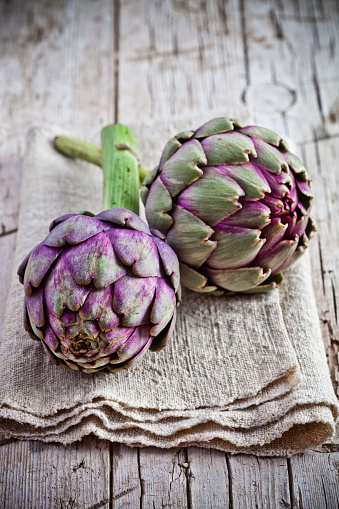 fresh artichokes on rustic wooden background