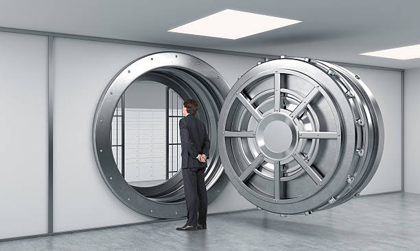 istock man standing in front of a big unlocked round safe 499127968