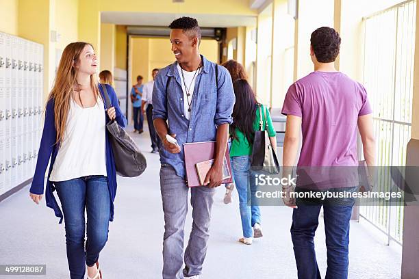 Group Of High School Students Walking Along Hallway Stock Photo - Download Image Now