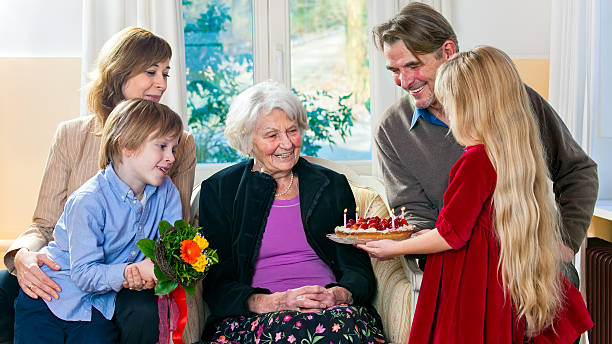 Grandma gets a birthday cake. Grandma gets a birthday cake from loving family. birthday wishes for daughter stock pictures, royalty-free photos & images