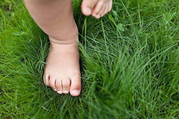 小さな赤ちゃんの足の緑の芝生。 - beautiful human toe human foot human leg ストックフォトと画像