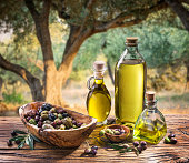 Olives and olive oil on the nature background.