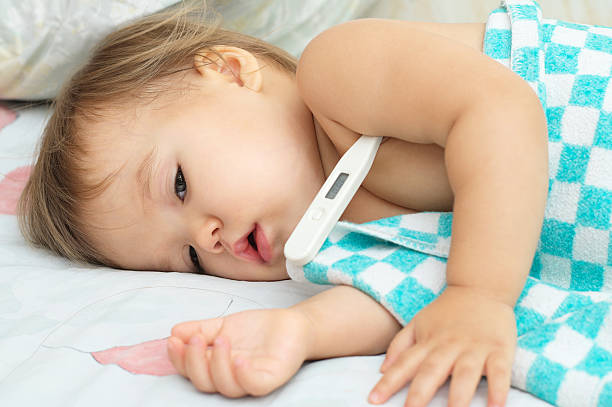 bebê em dificuldades e deitado com um termómetro - child fever illness thermometer imagens e fotografias de stock