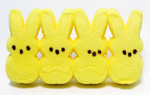 Four yellow candy marshmallow Easter bunnies. Generic brand. Horizontal.