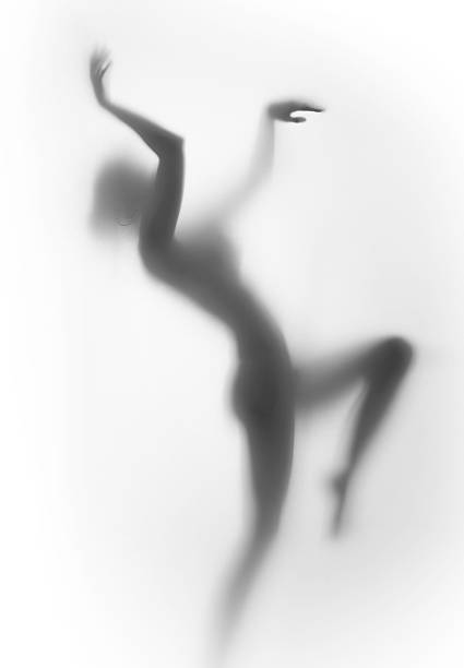 Female human dancing body silhouette, behind a glass surface