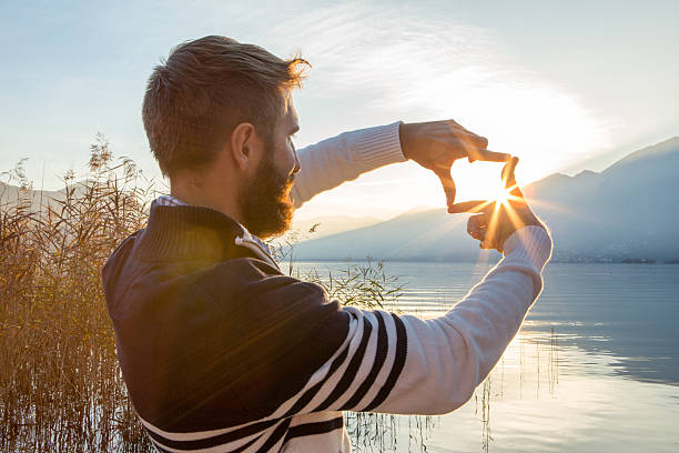 homem mãos frame pôr do sol sobre o lago de montanha - imagination creativity finger frame frame imagens e fotografias de stock