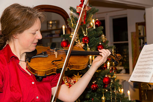 istock woman is playing violin at christmas 499151872