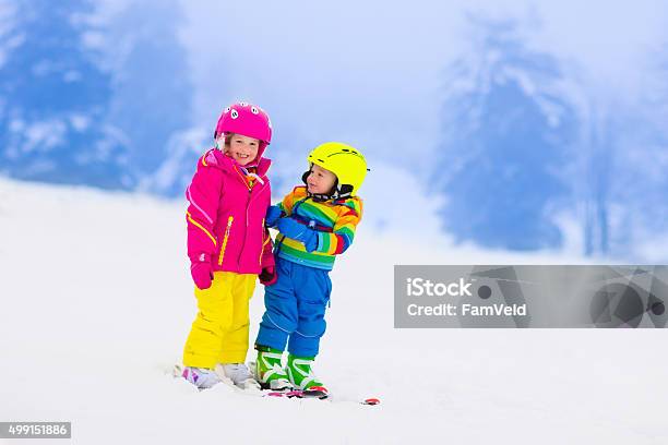 Two Children Skiing In Snowy Mountains Stock Photo - Download Image Now - Skiing, Child, Fun