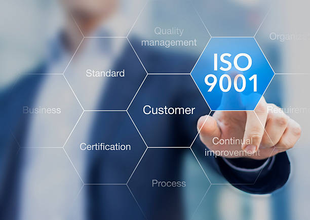 ISO 9001 standard for quality management of organizations ISO 9001 standard for quality management of organizations with an auditor or manager in background 2015 stock pictures, royalty-free photos & images