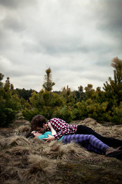 teenagers (14-15) lying on ground and kissing - teenage sex fotografías e imágenes de stock