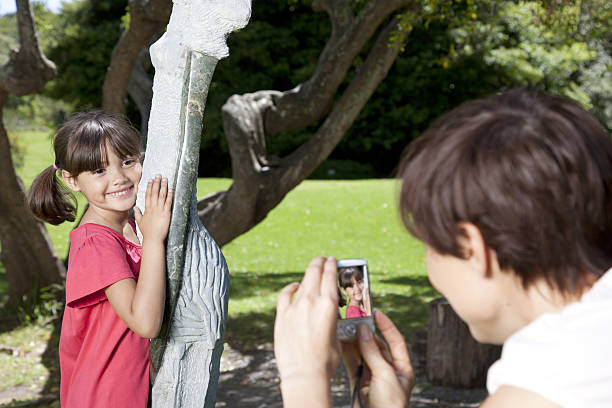 mother taking photograph of child in park - 30136 뉴스 사진 이미지